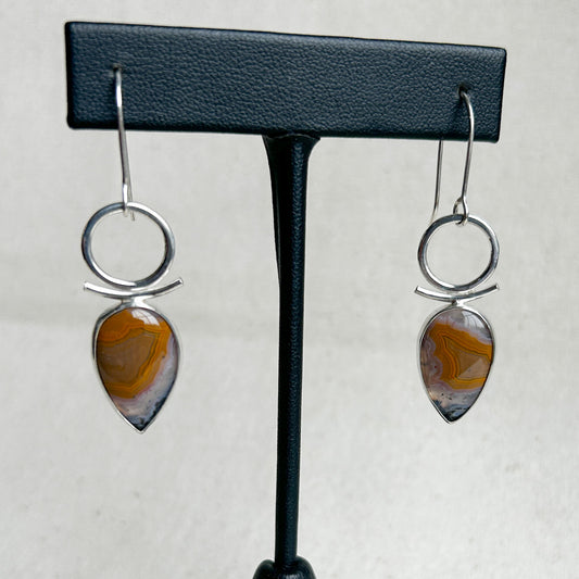 Teardrop shaped agate and silver  earrings on black stand