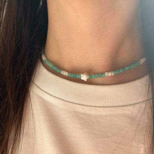 Close-up of a person wearing a turquoise beaded necklace.