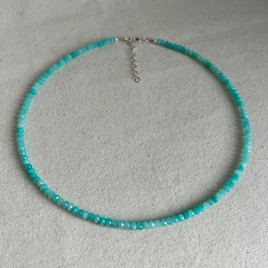 Turquoise beaded necklace on a light gray background