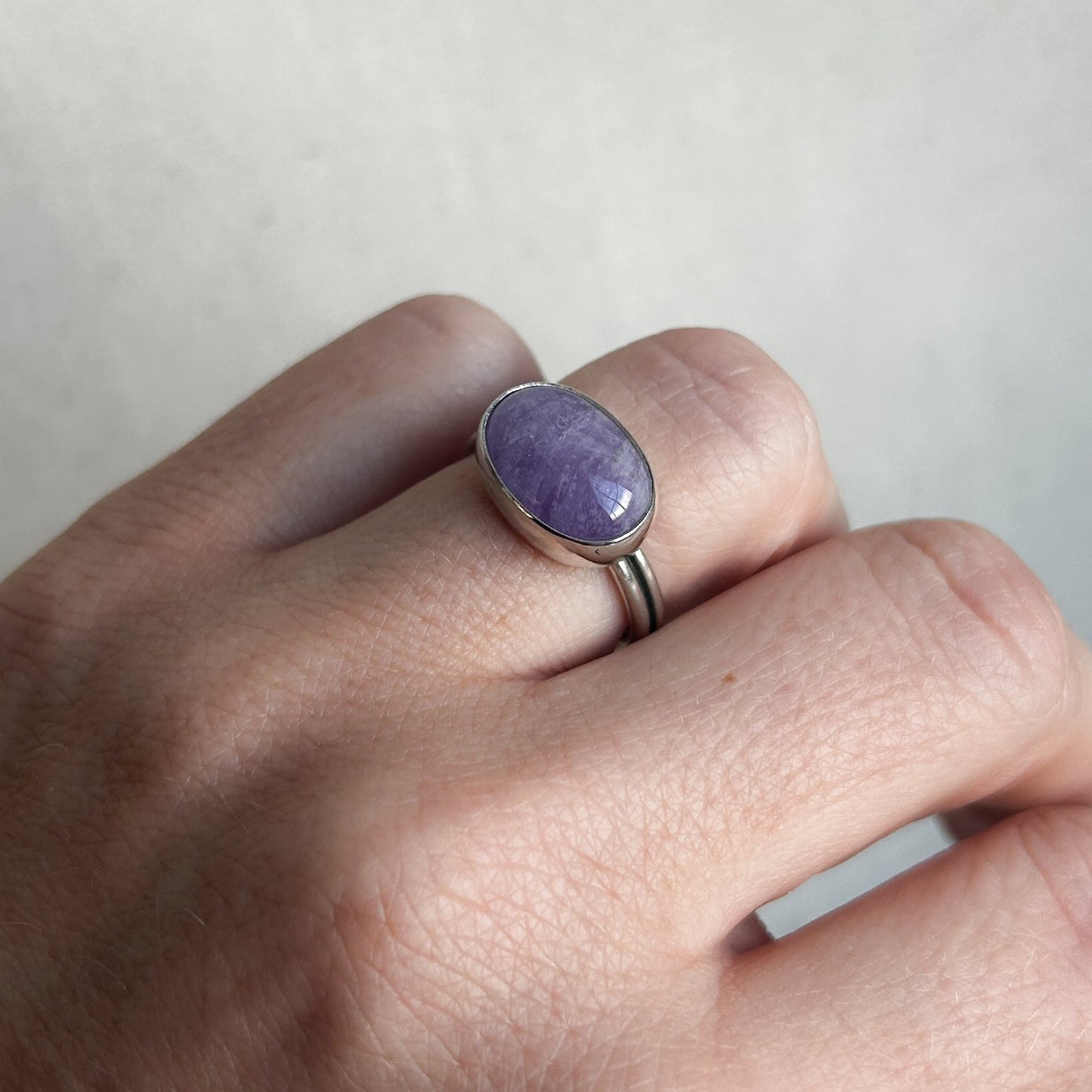 Purple amethyst ring with silver band on model's finger