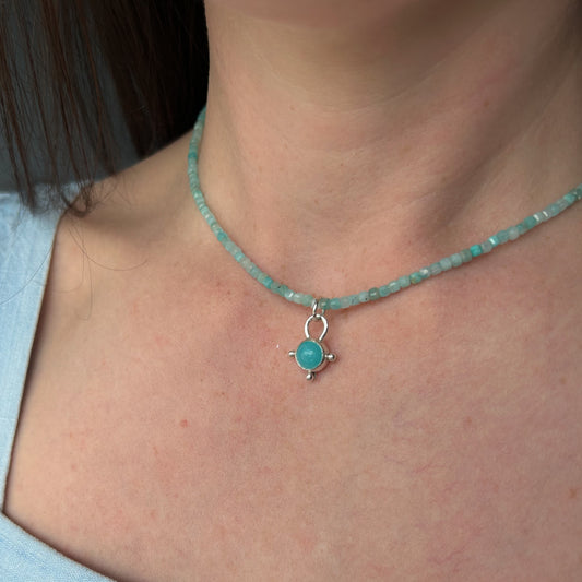 Necklace with a turquoise pendant worn by a person