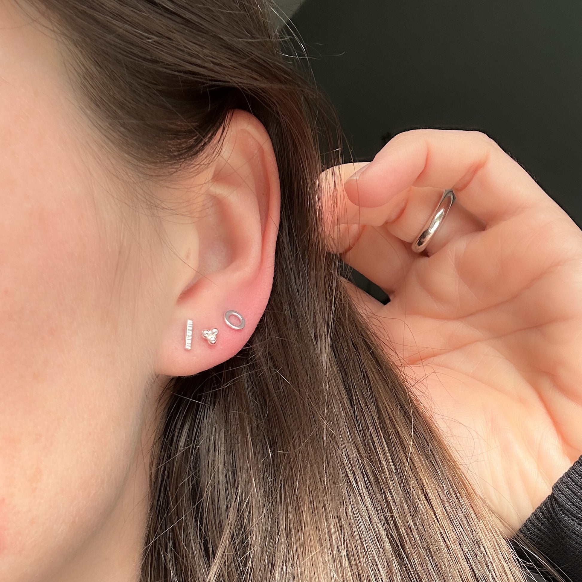 Silver studs in a row on model's ear