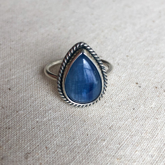 Kyanite ring with a sterling silver band against a grey background