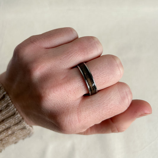 Hand wearing a ring on a neutral background