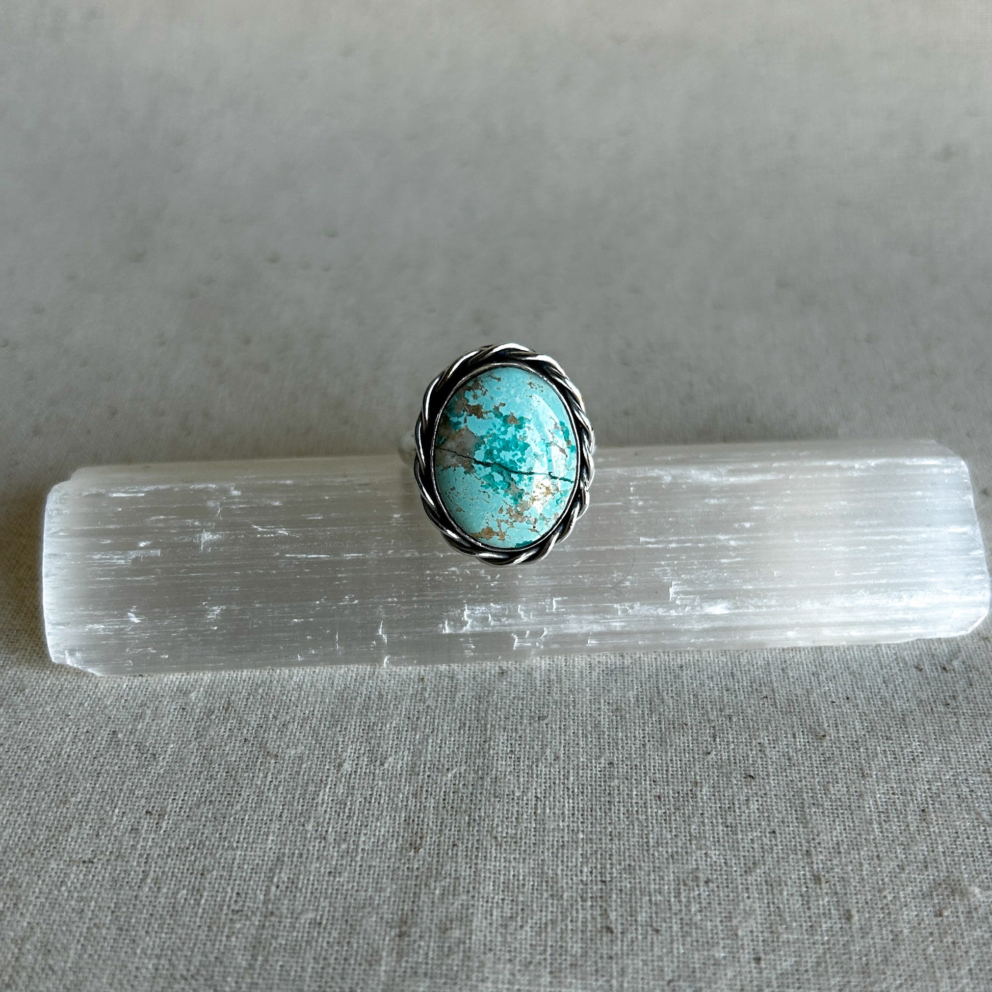 Silver rope ring with large turquoise gemstone and twisted rope-style border