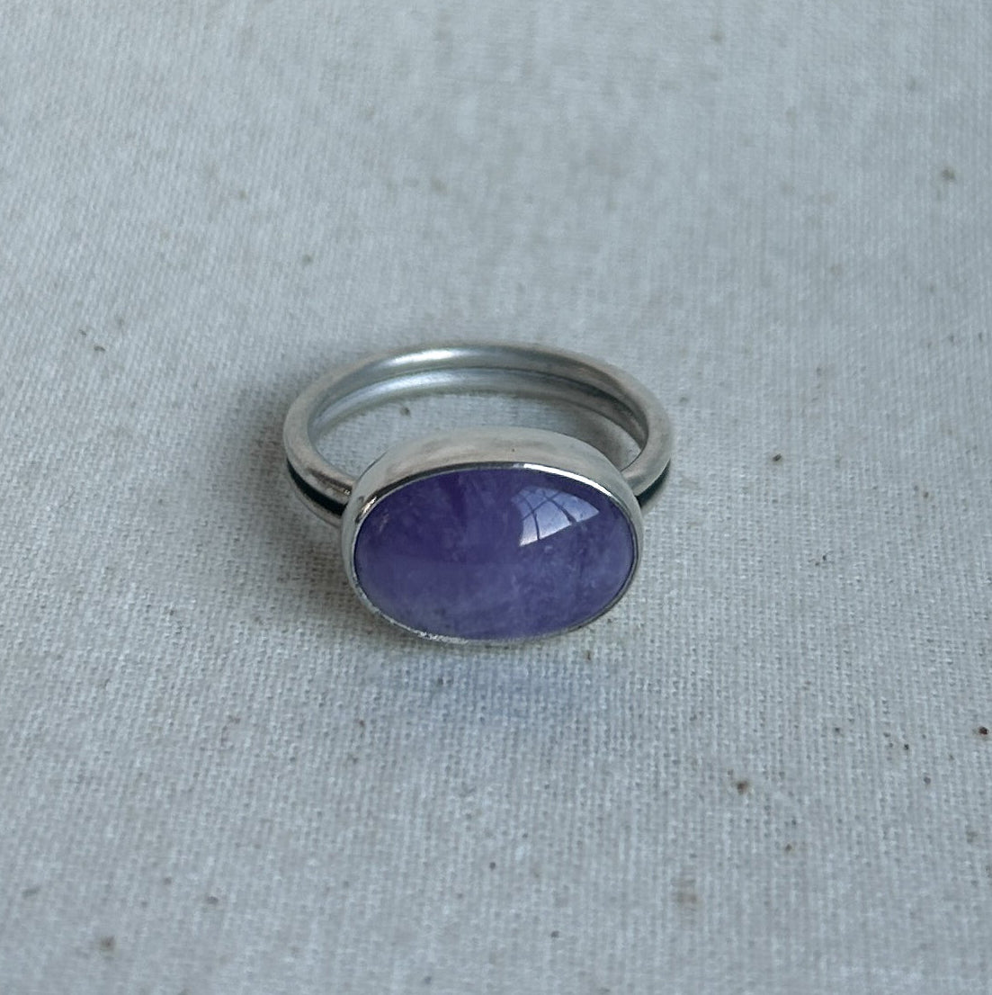 Oval amethyst ring on linen background