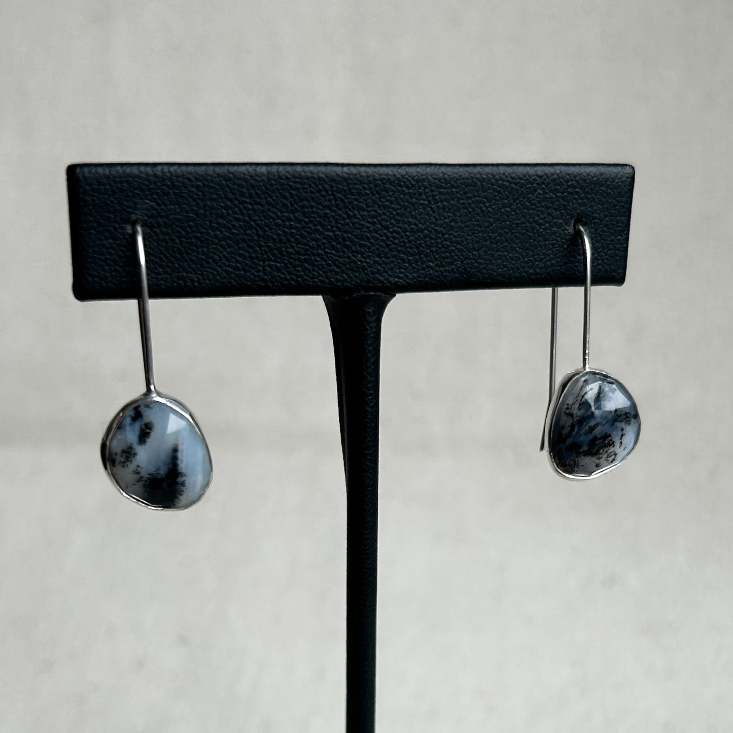 Black and white Peruvian Opal earrings on display stands