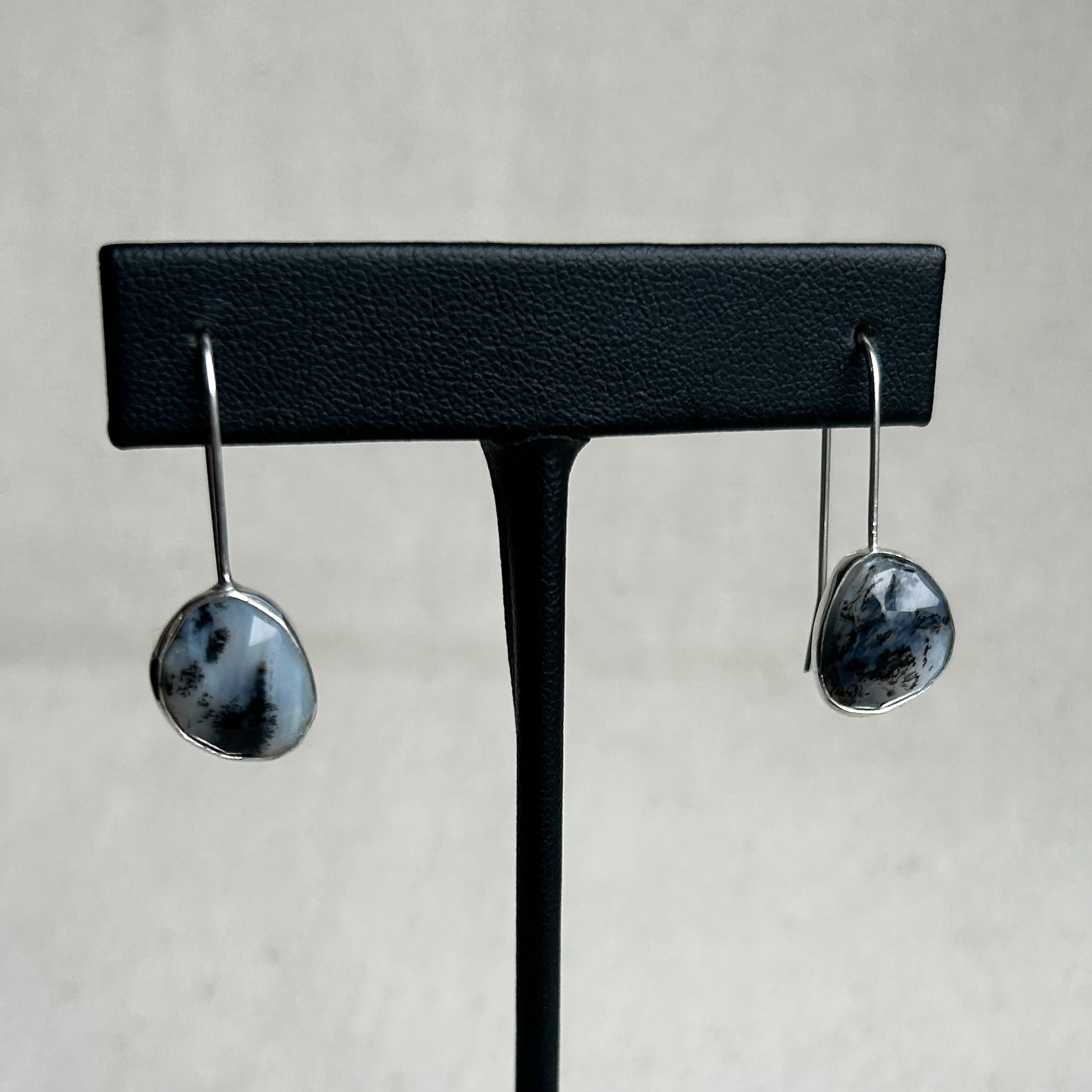 Black and white Peruvian Opal earrings on display stands