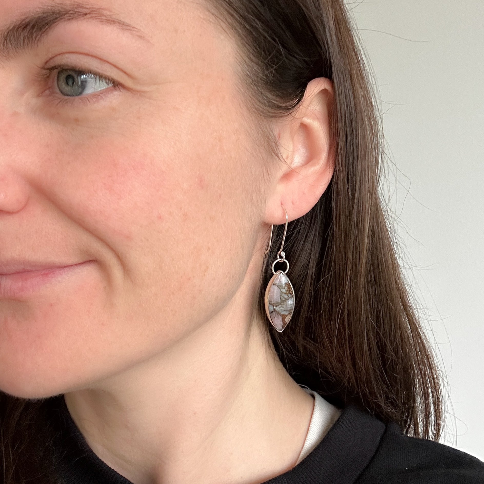 Marquise shaped pink Opal earrings being worn on model