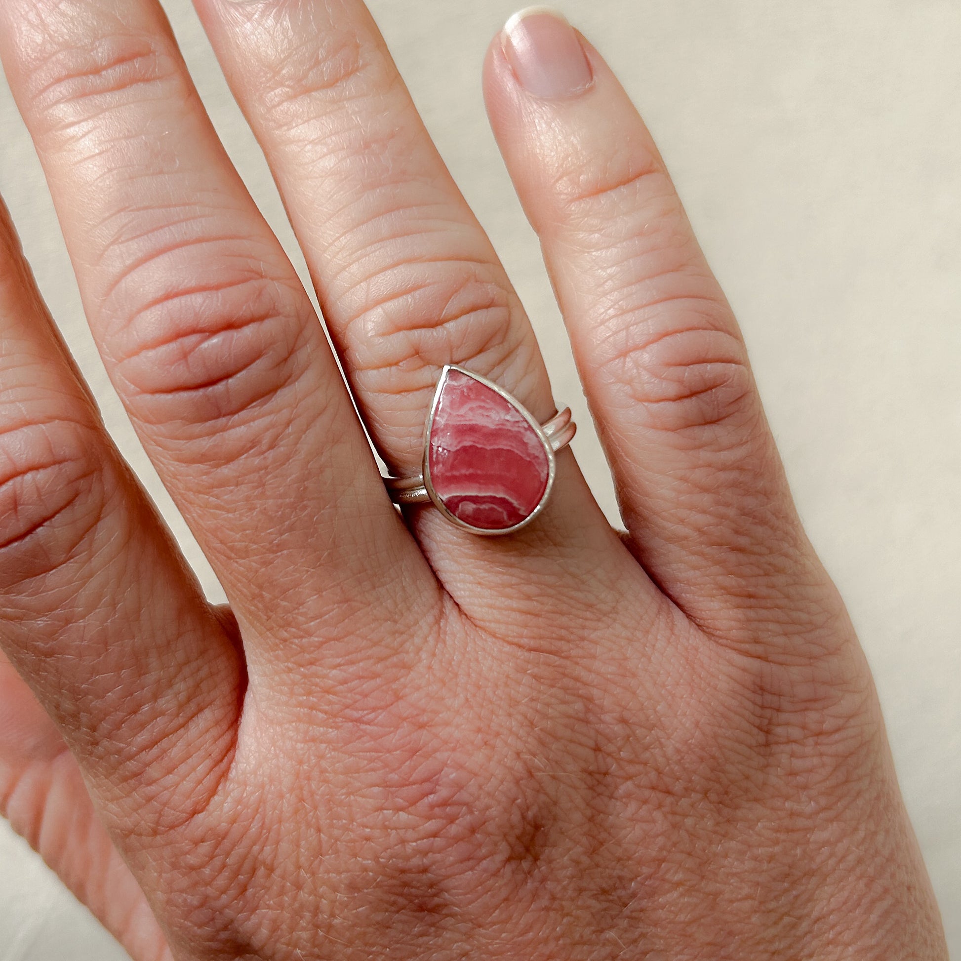 Pink rhodochrosite ring on model's hand