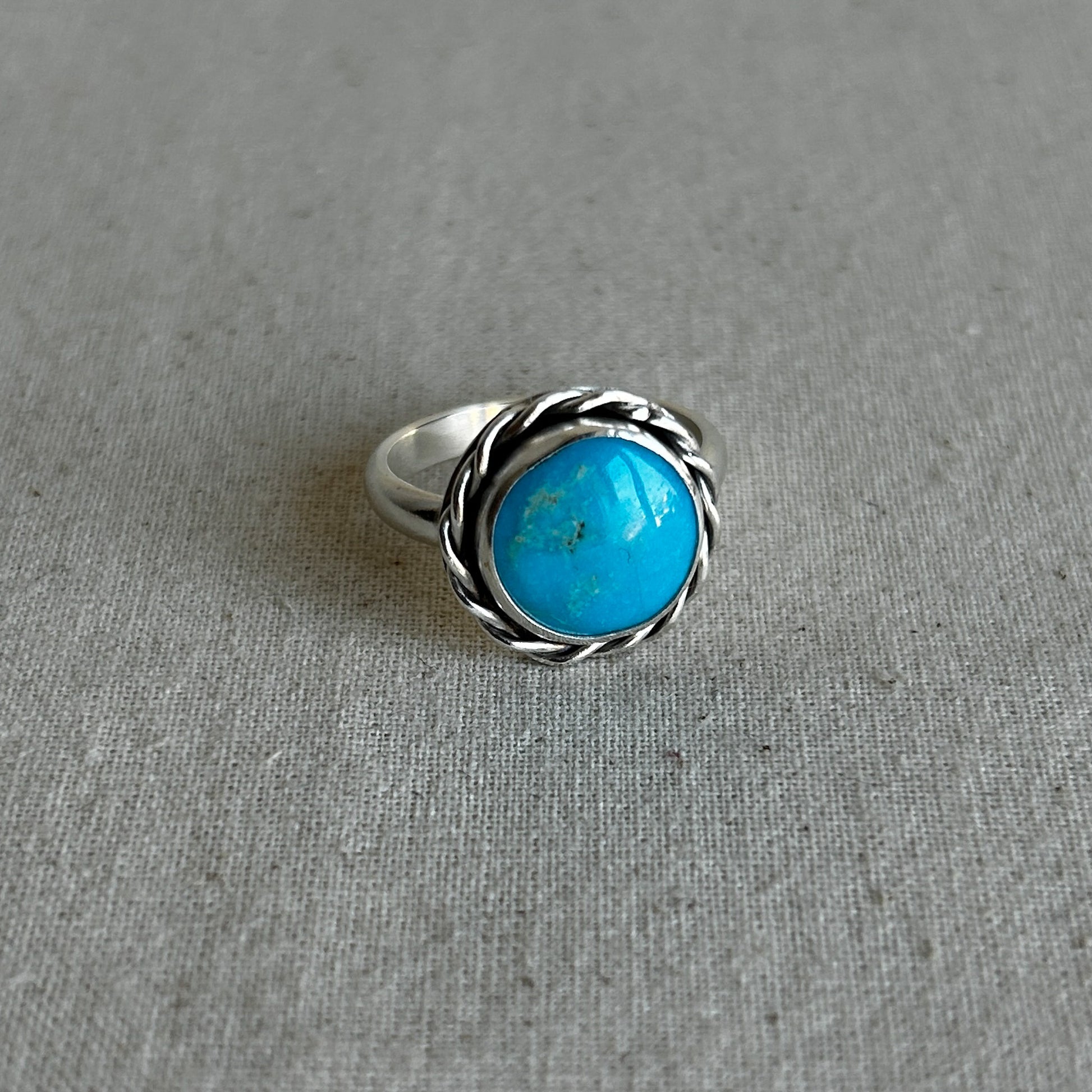 Turquoise gemstone ring on grey background