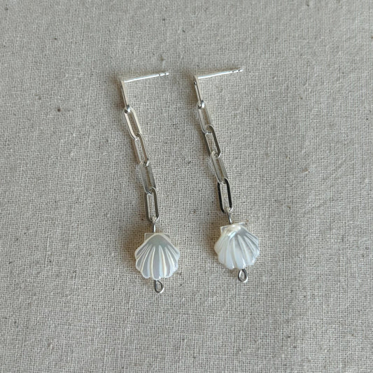 White shells on a silver chain earring on grey background