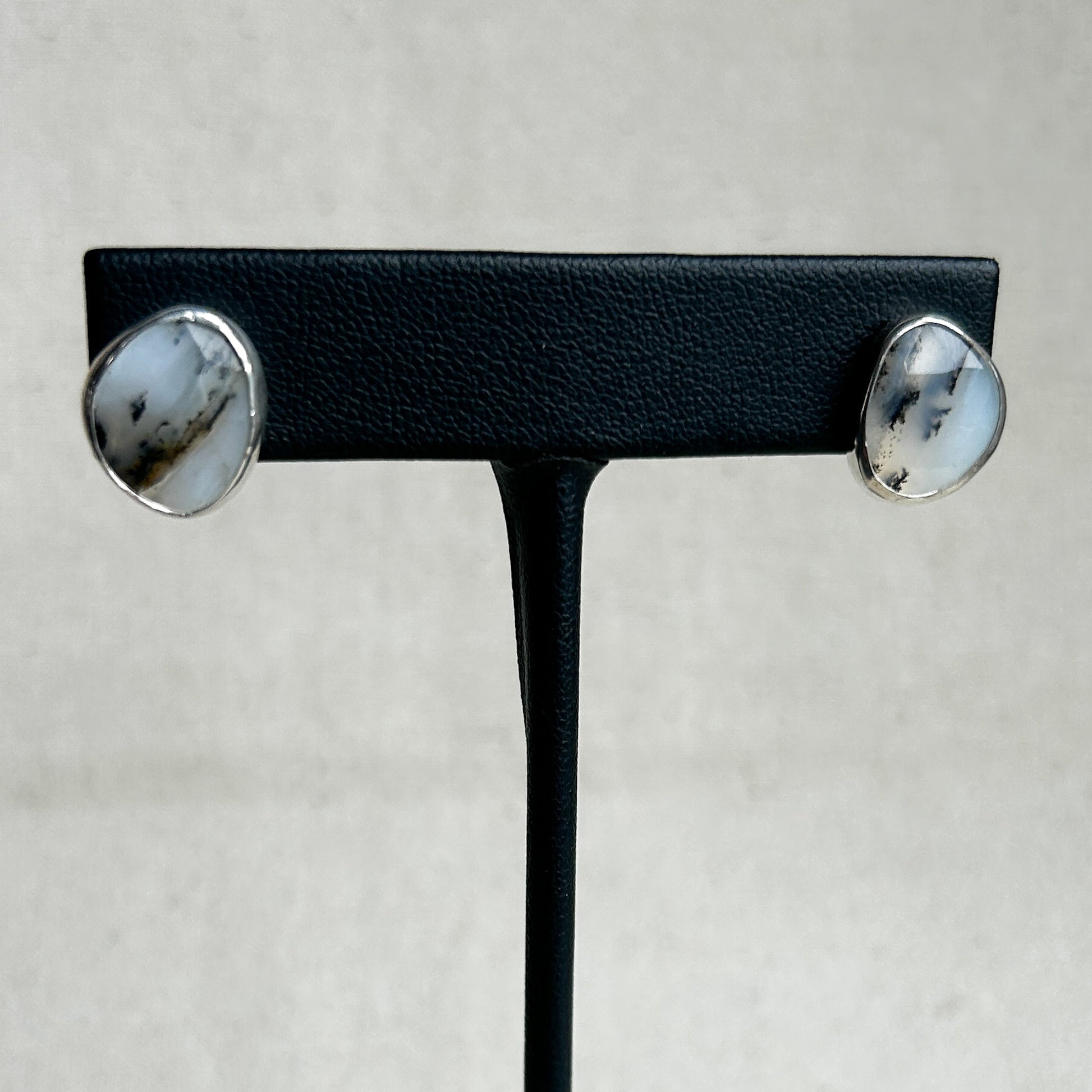 Black and white opal stud earrings on black stand