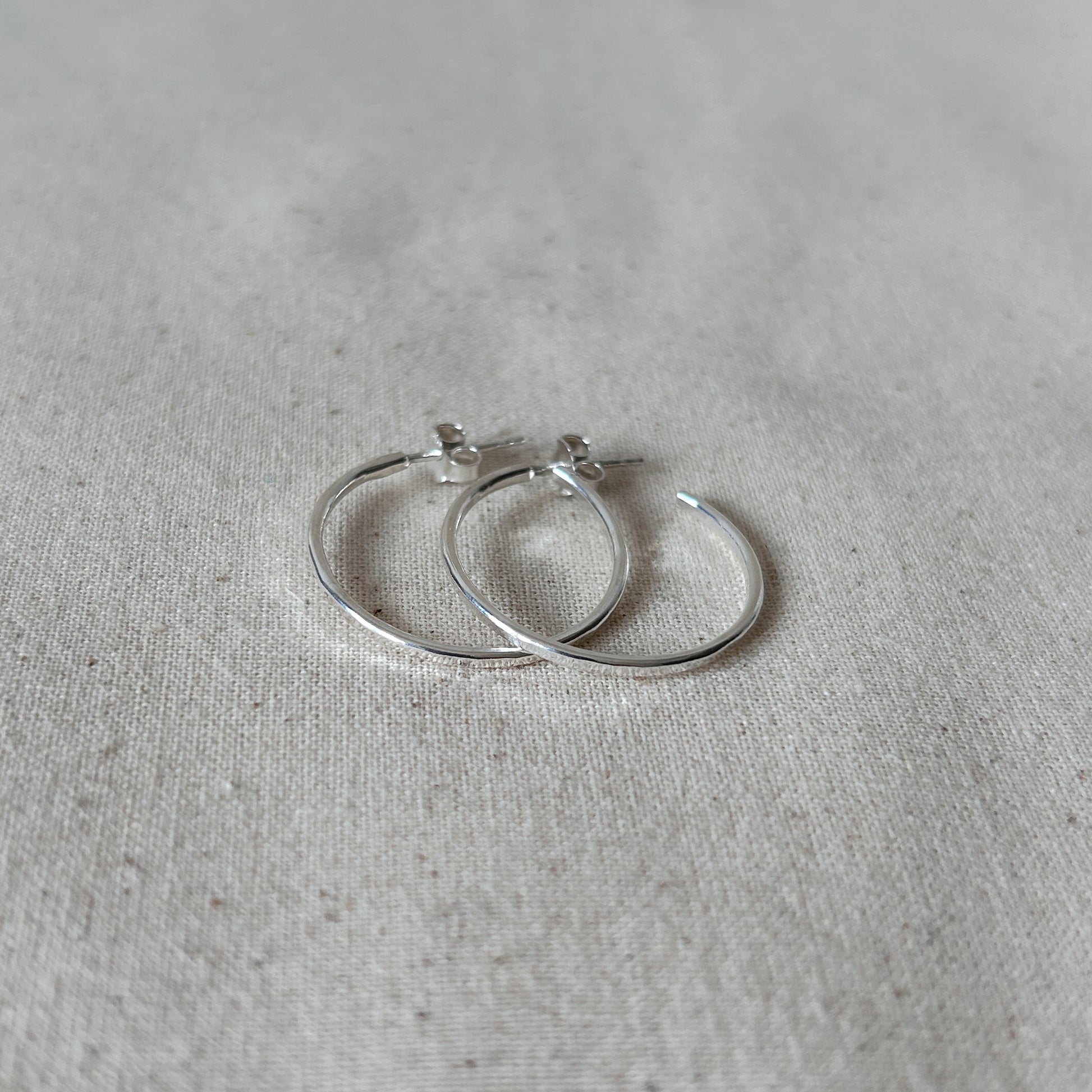 Silver handmade earrings on a grey background