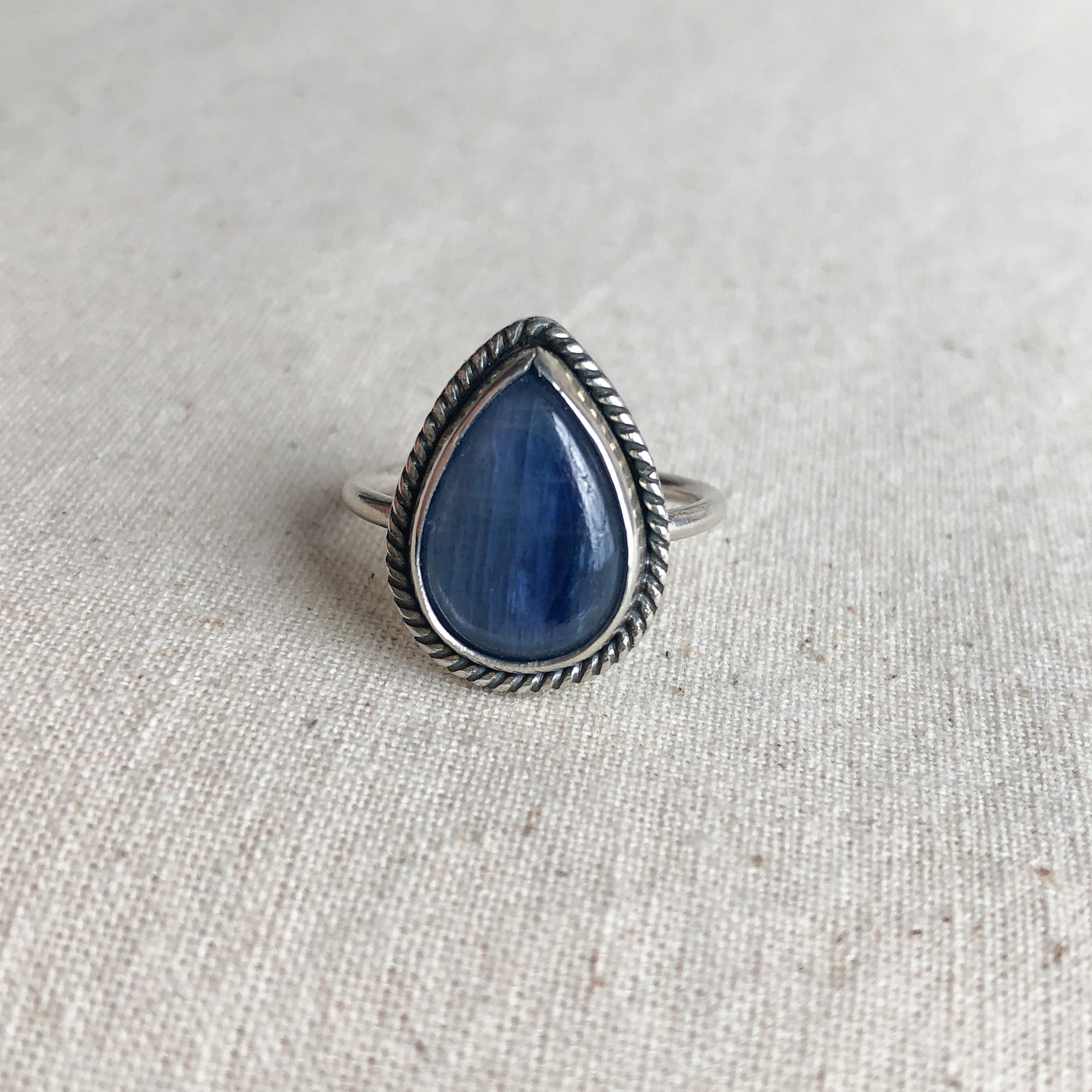 Sterling silver teardrop kyanite ring on grey background