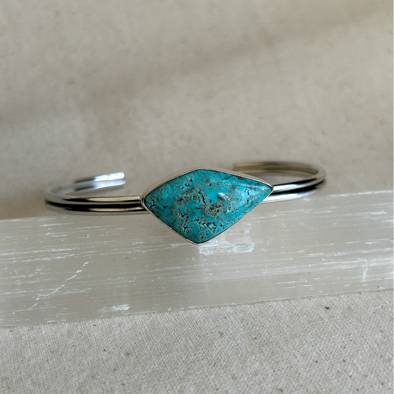 Kite shaped turquoise stone set on a silver cuff bracelet