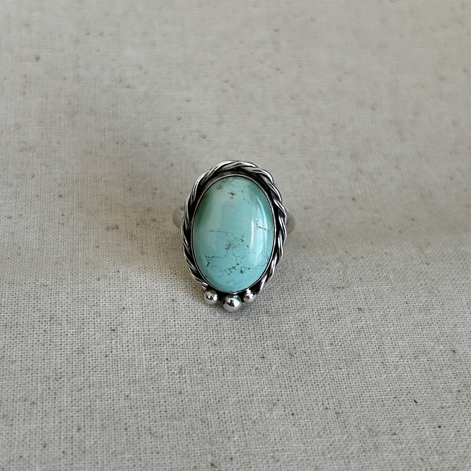 Silver turquoise ring set in Argentium against a grey background