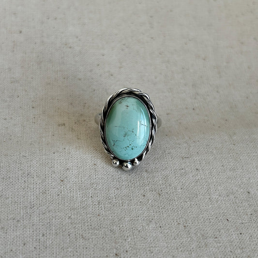 Silver turquoise ring set in Argentium against a grey background