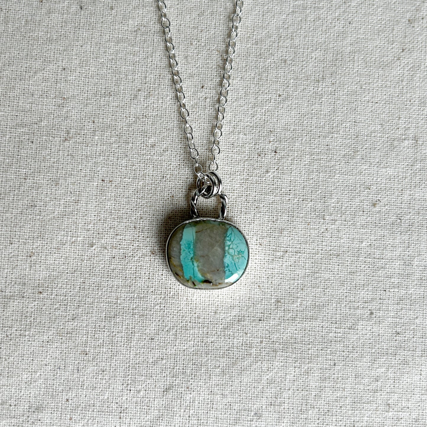 Turquoise and grey striped gemstone pendant with a twisted rope-style bail