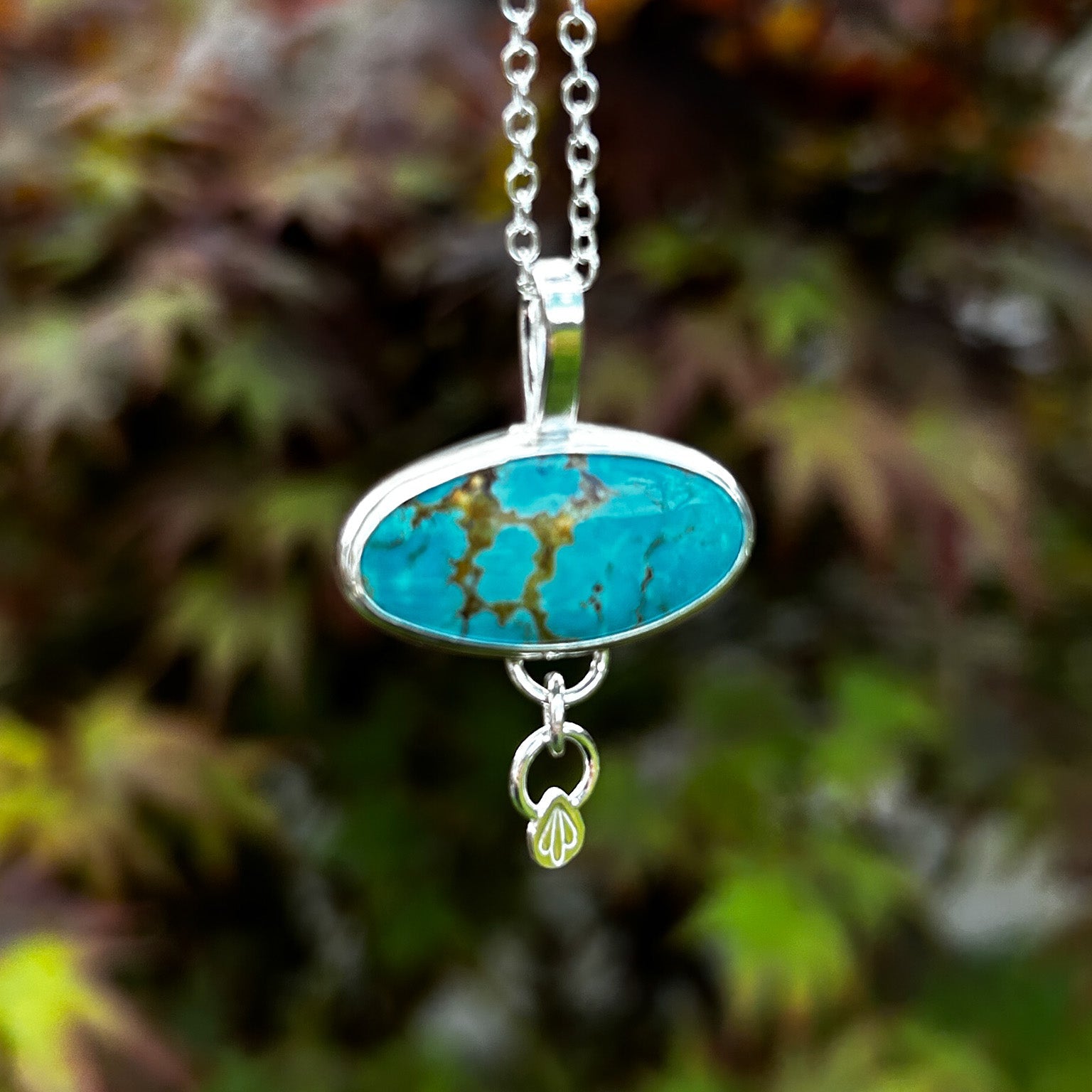 Turquoise pendant necklace with a blurred natural background