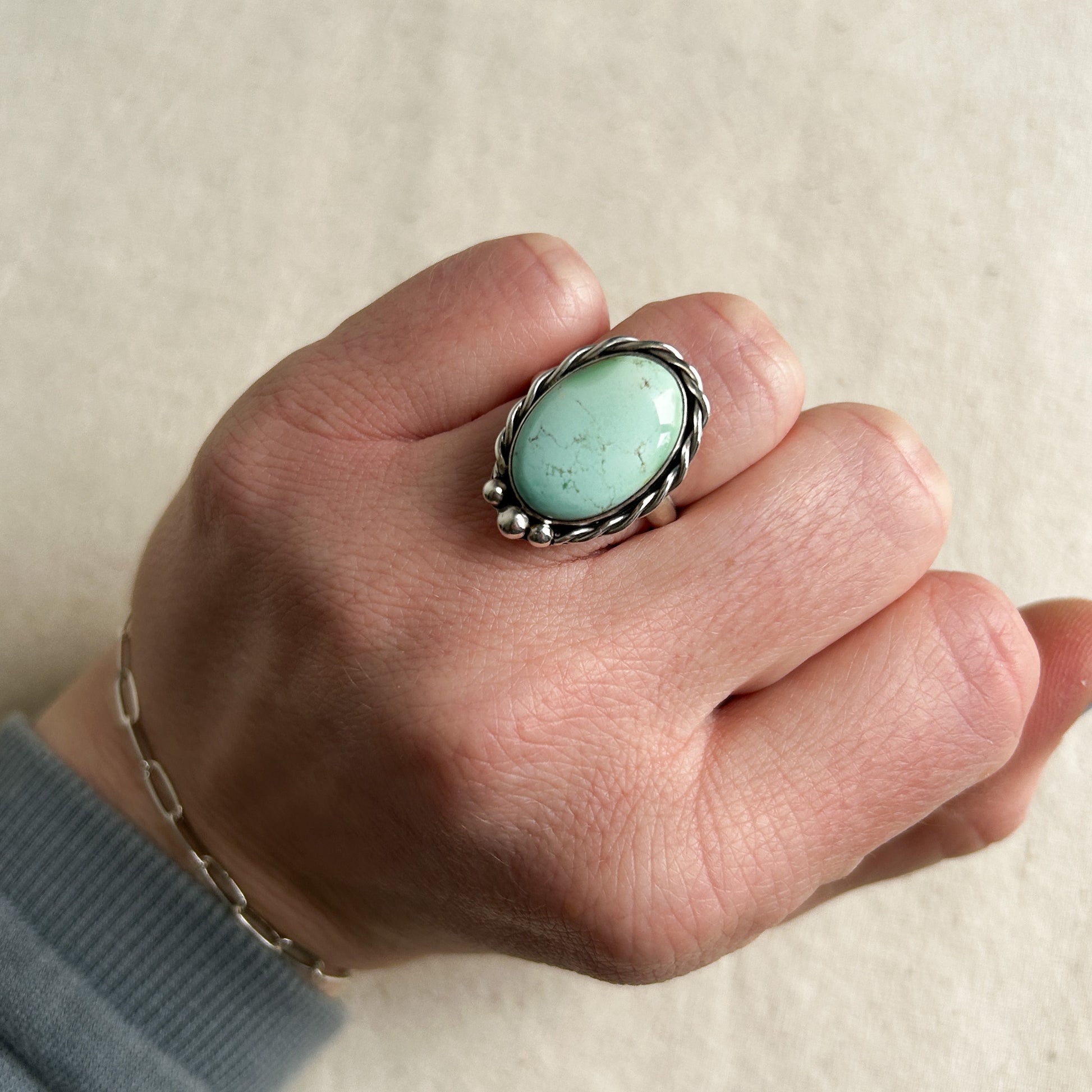 Turquoise silver ring with pale blue gemstone on models hand