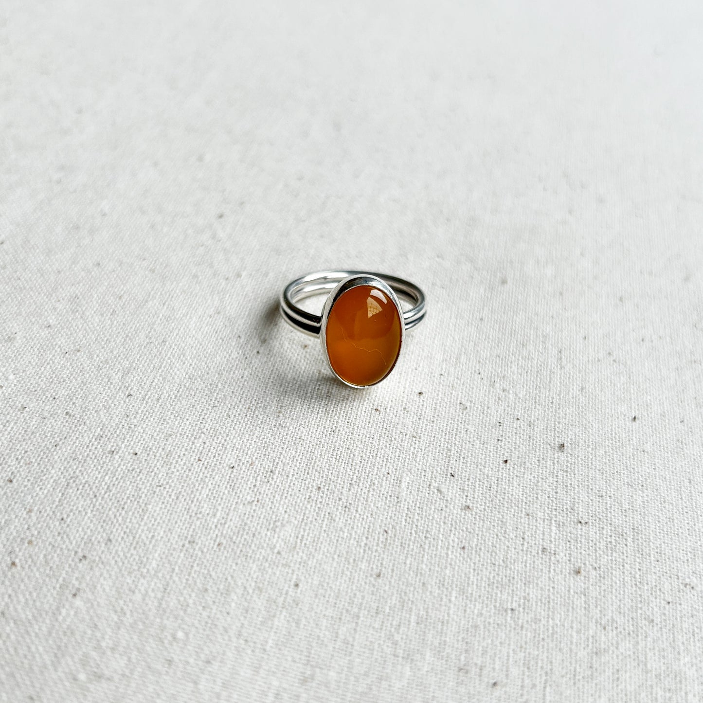 Silver chalcedony ring with yellow gemstone on a white background