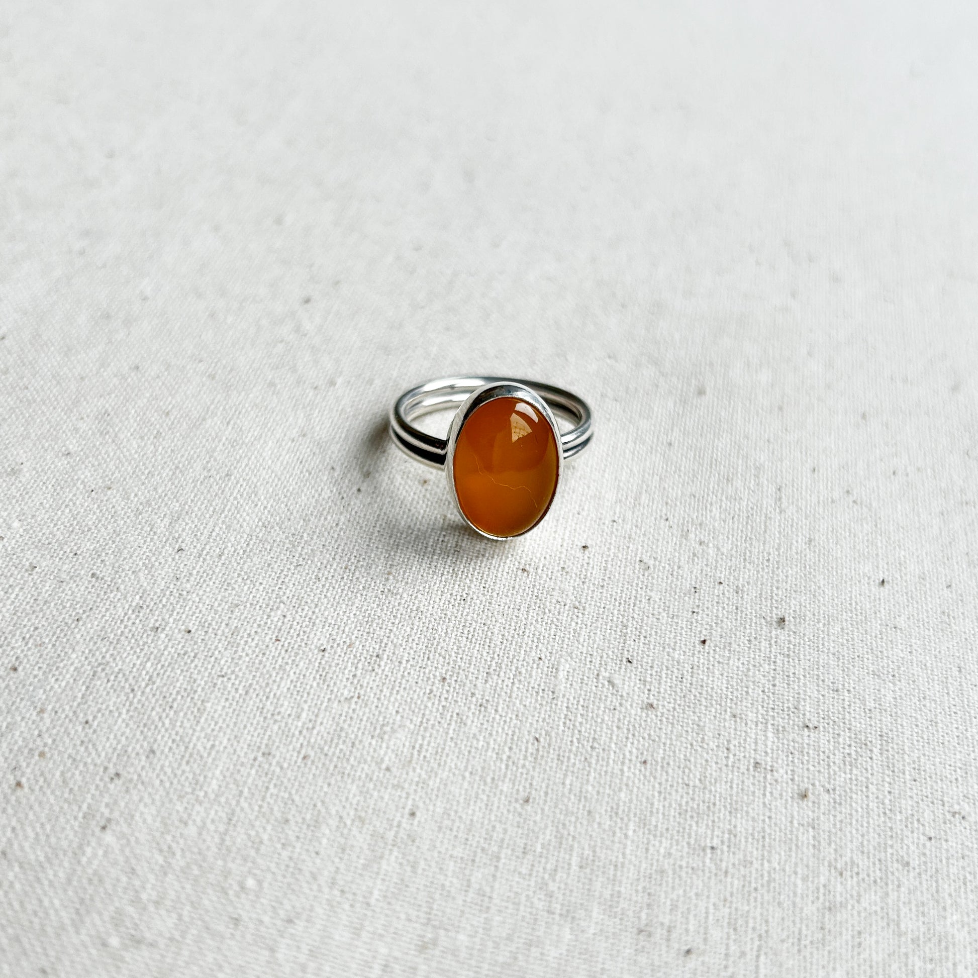 Silver chalcedony ring with yellow gemstone on a white background