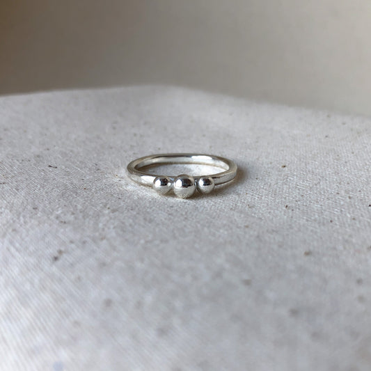 Silver 3 ball ring on grey background