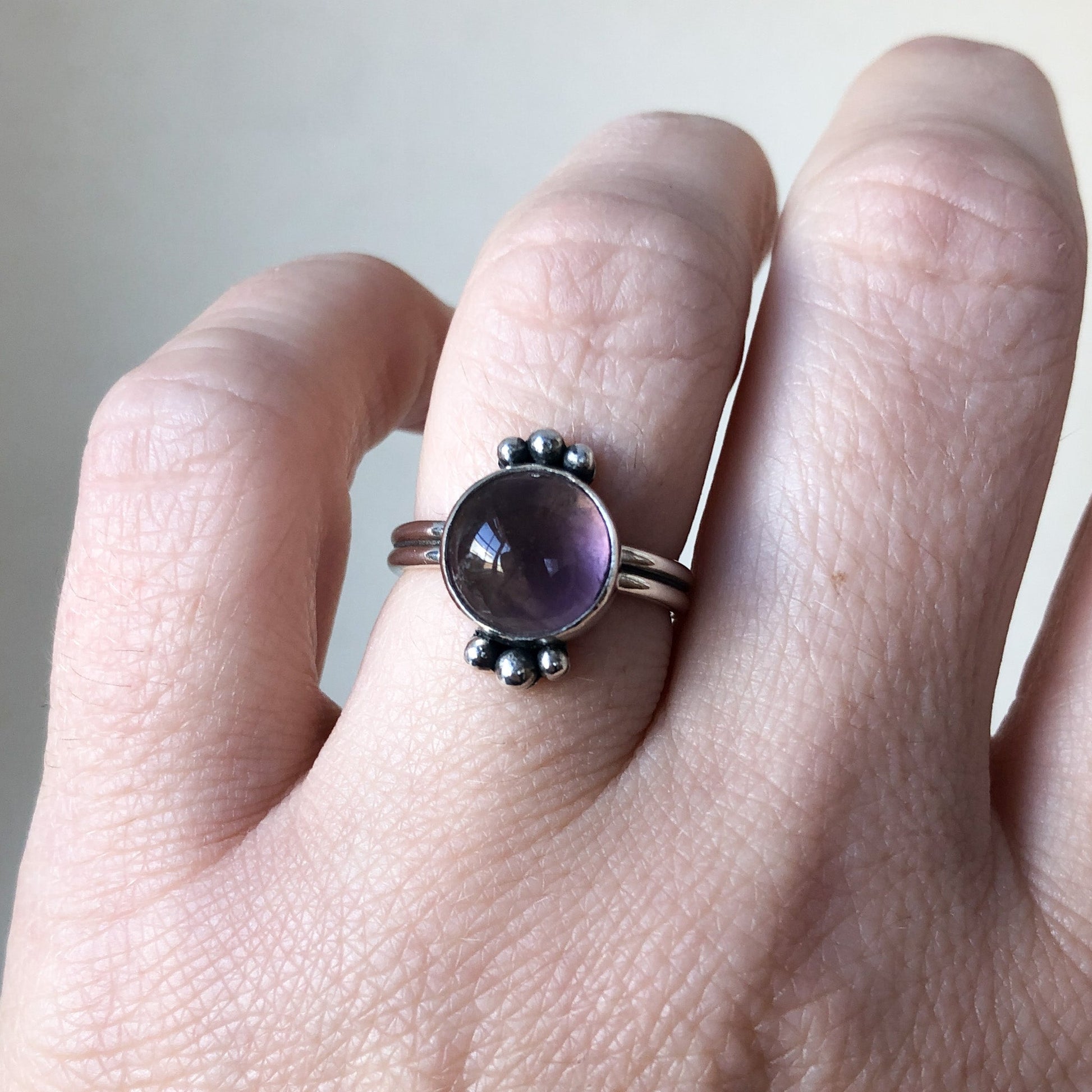 Silver amethyst ring with silver band on model's hand