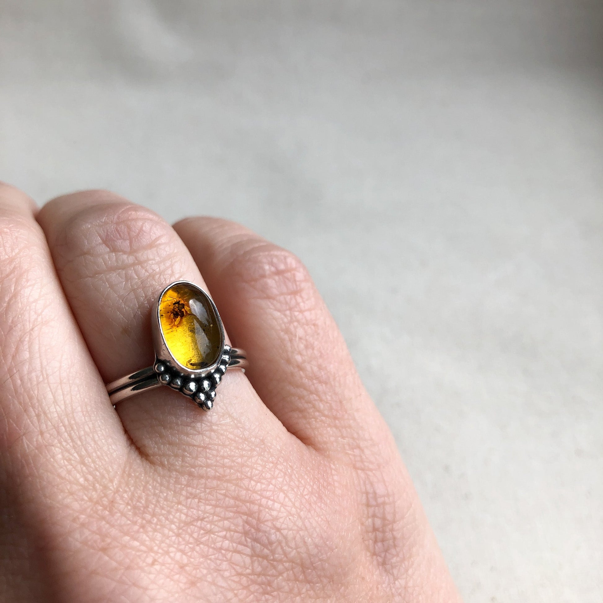 Argentium silver amber gemstone ring on model's hand