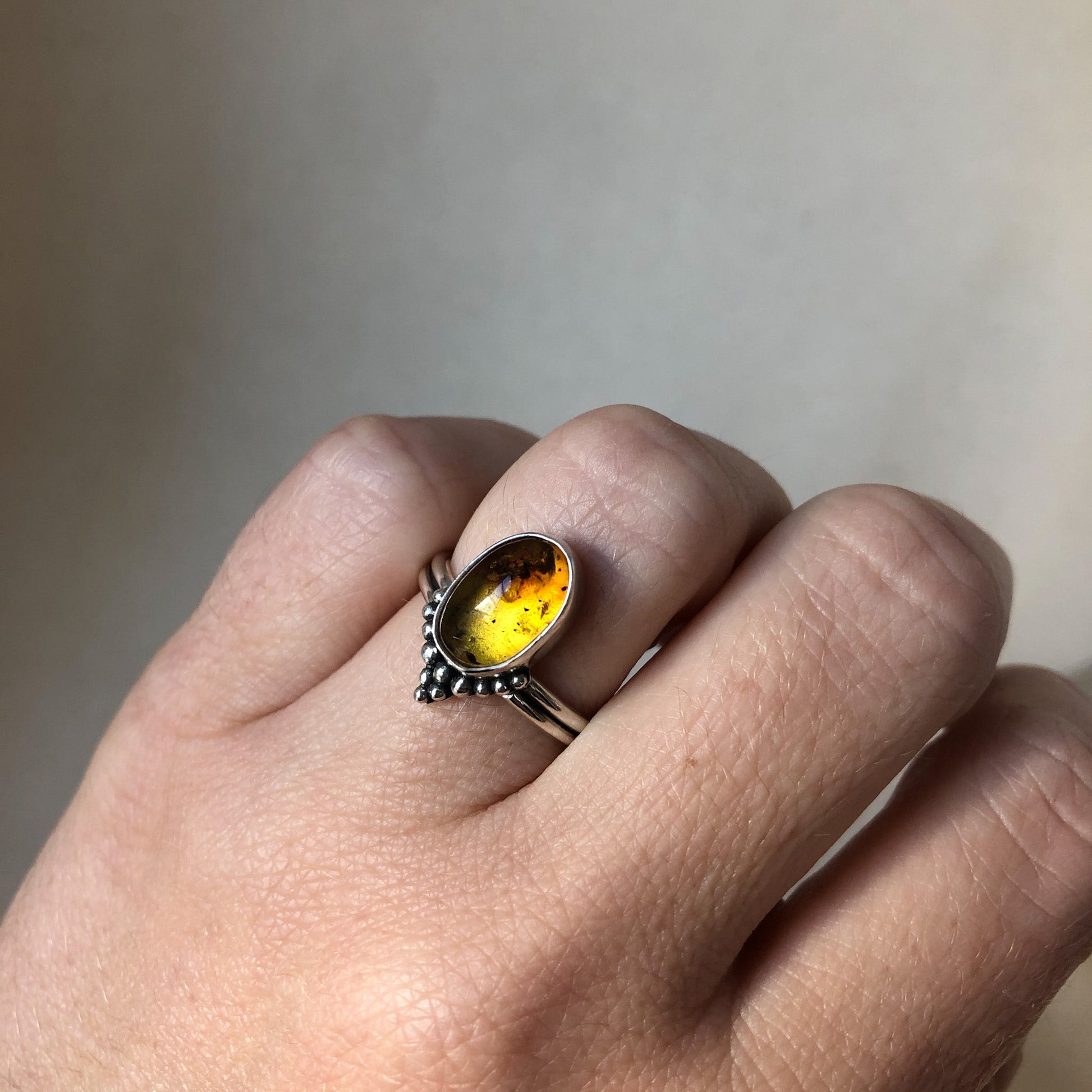 Handmade amber ring on model's hand