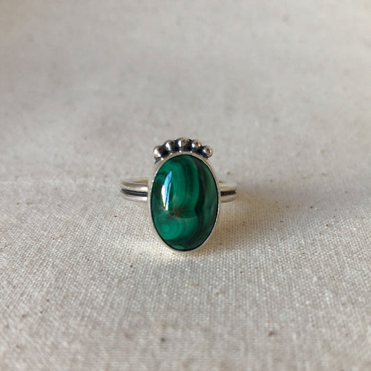 Green malachite ring with silver band  on grey background