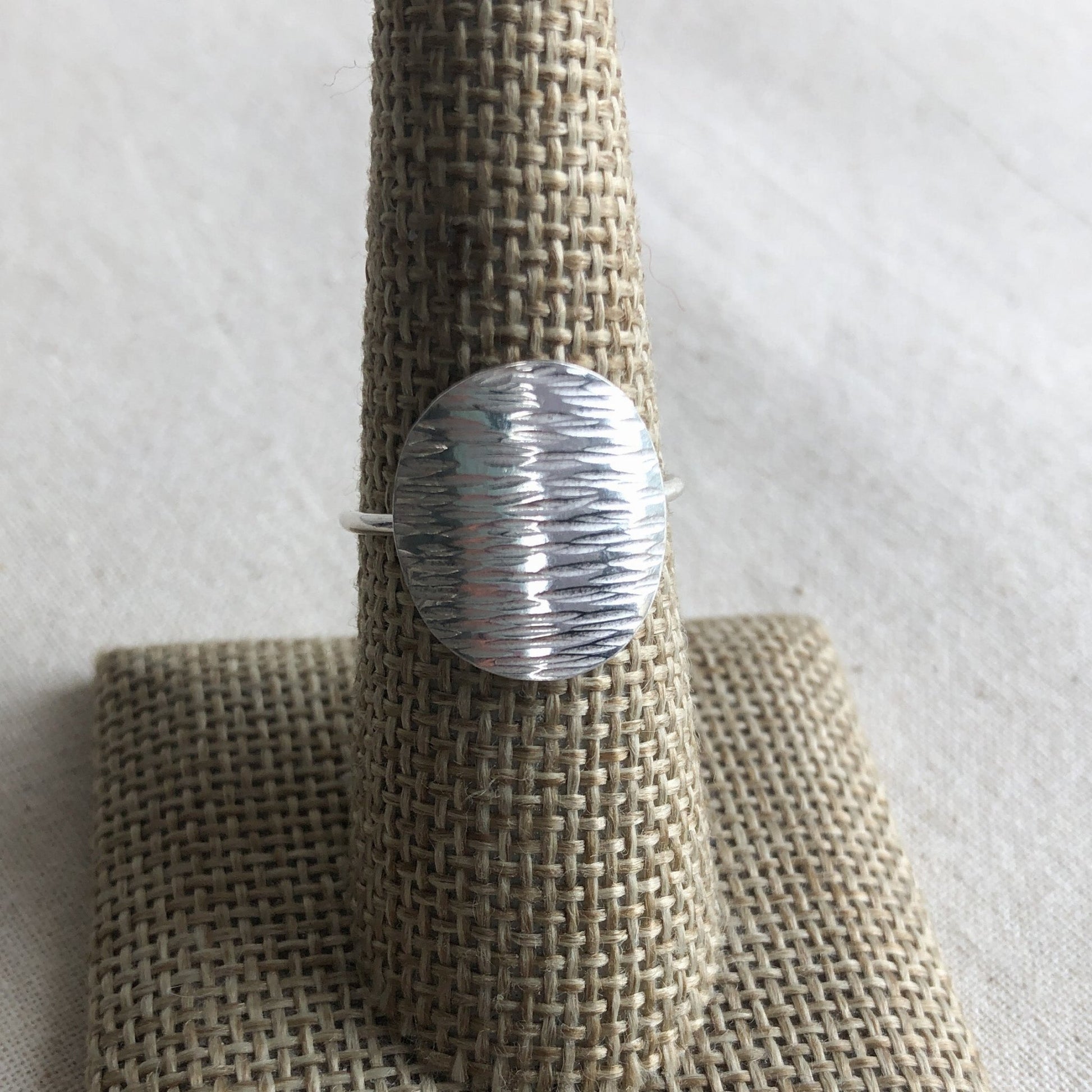 Sterling silver disc ring on display stand