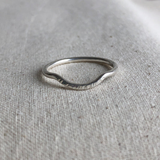 Sterling silver curved stacking ring on grey background