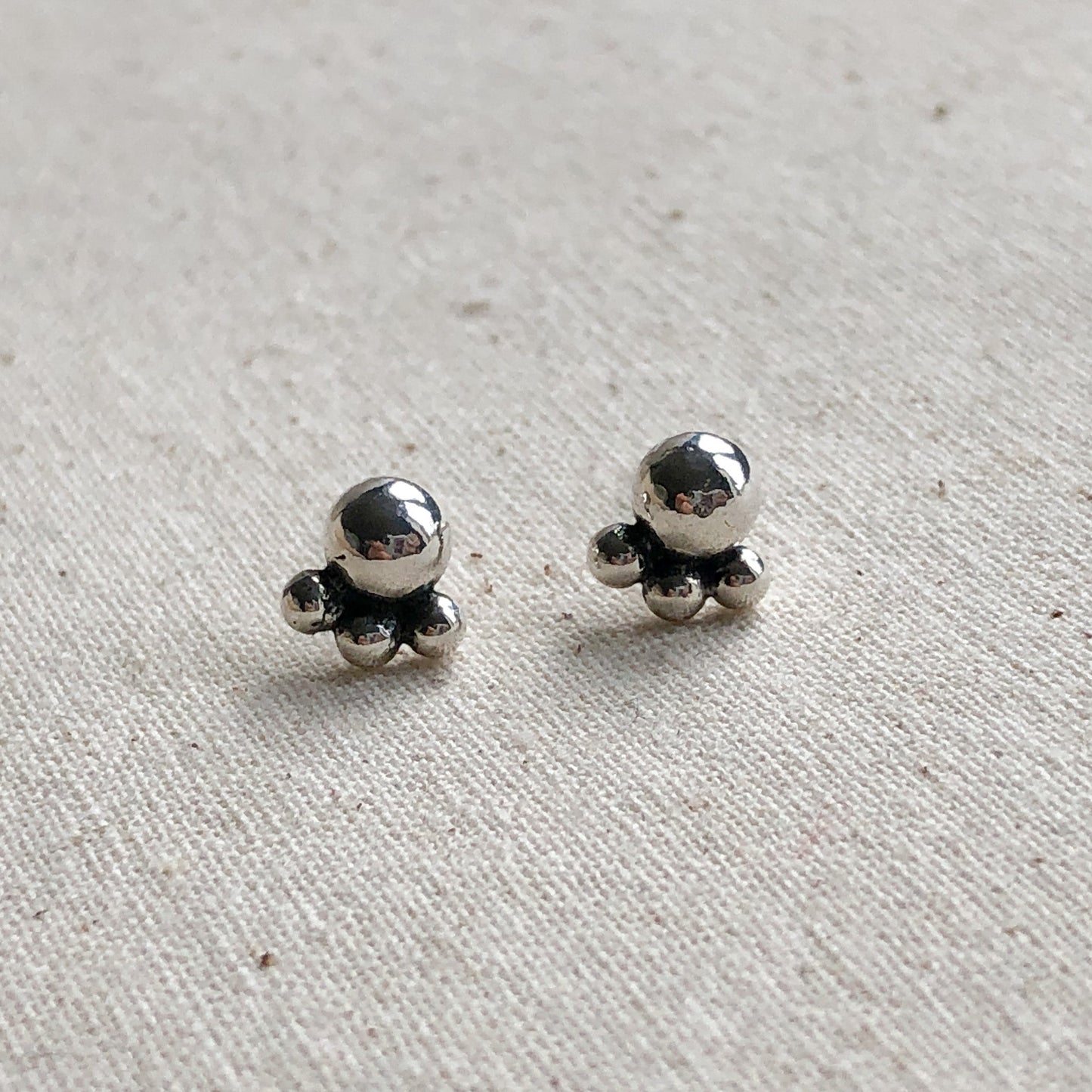 Stud Earrings made of Argentium silver on grey background.