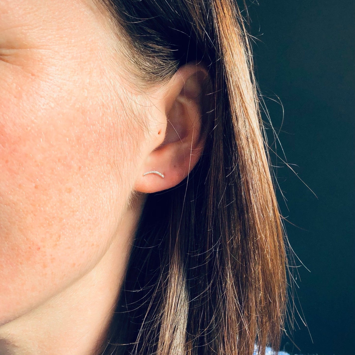 Model wearing sterling silver bar stud earrings