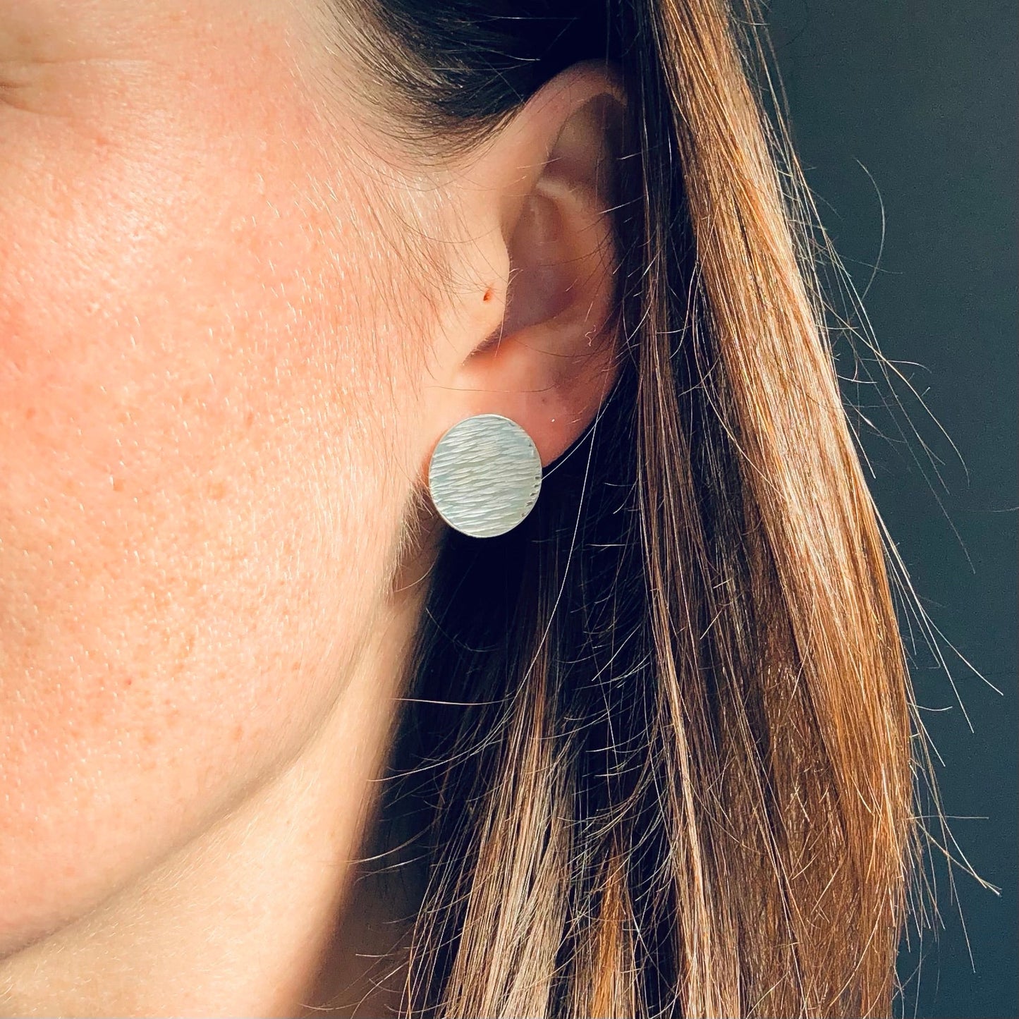 Model Wearing Round Silver Disc Earrings with Hammered Texture