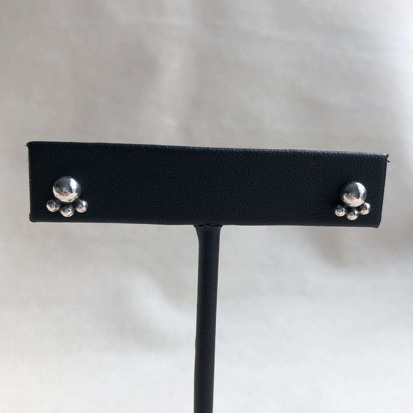 Argentium ball studs earrings on black display stand.