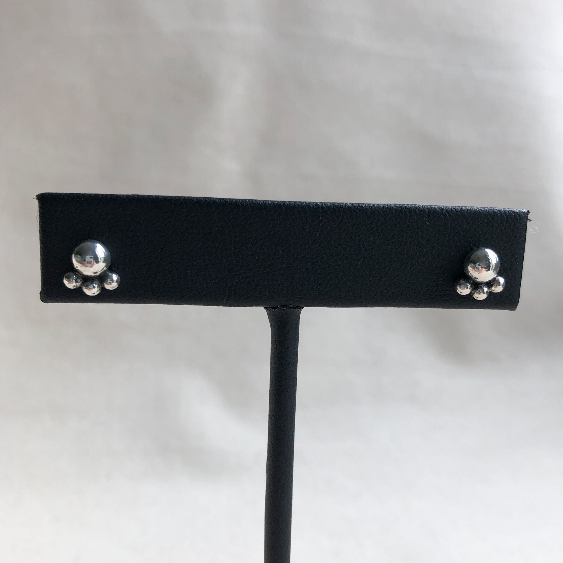 Argentium ball studs earrings on black display stand.