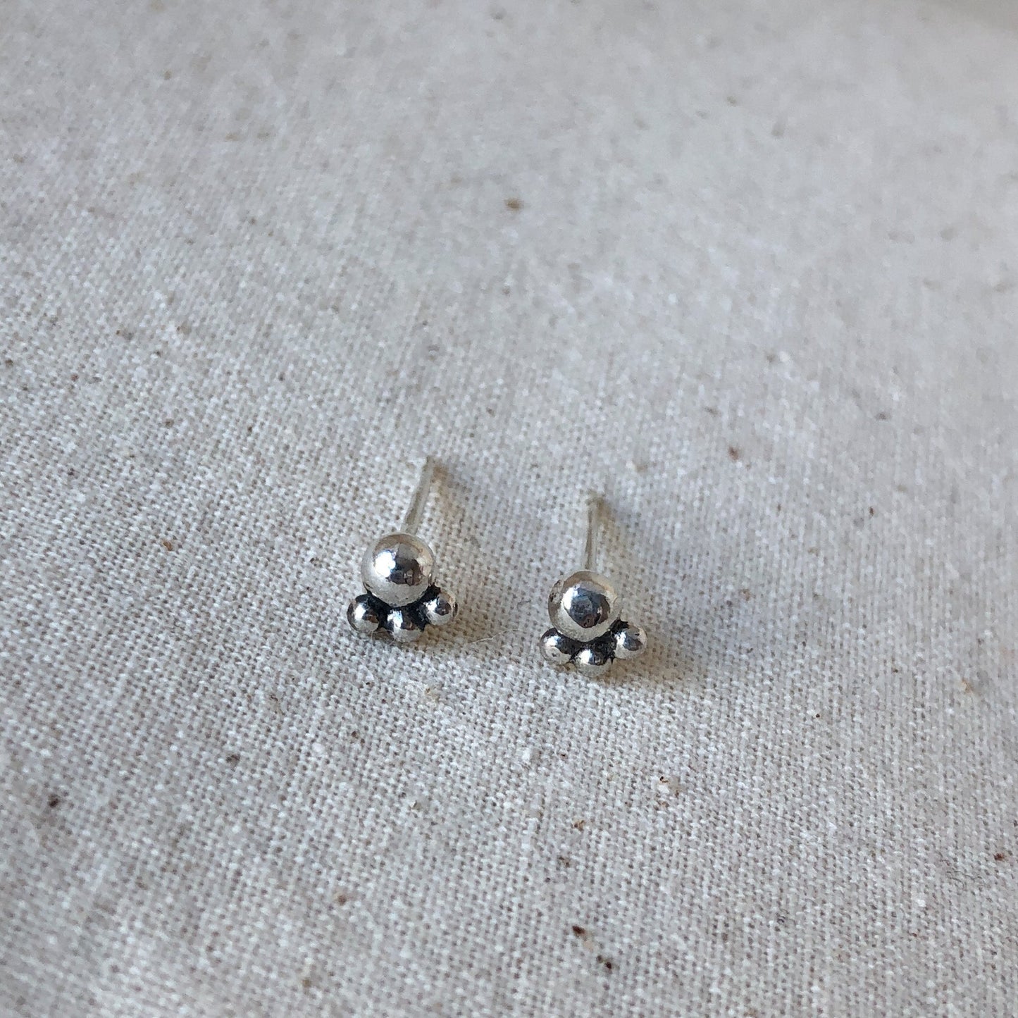 Silver ball stud earrings on grey background