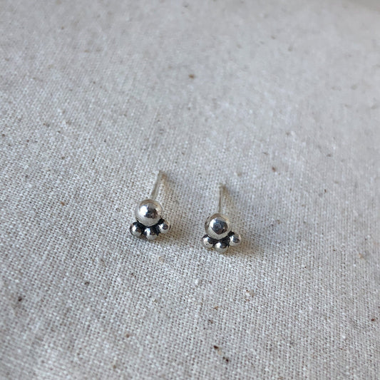 Silver ball stud earrings on grey background