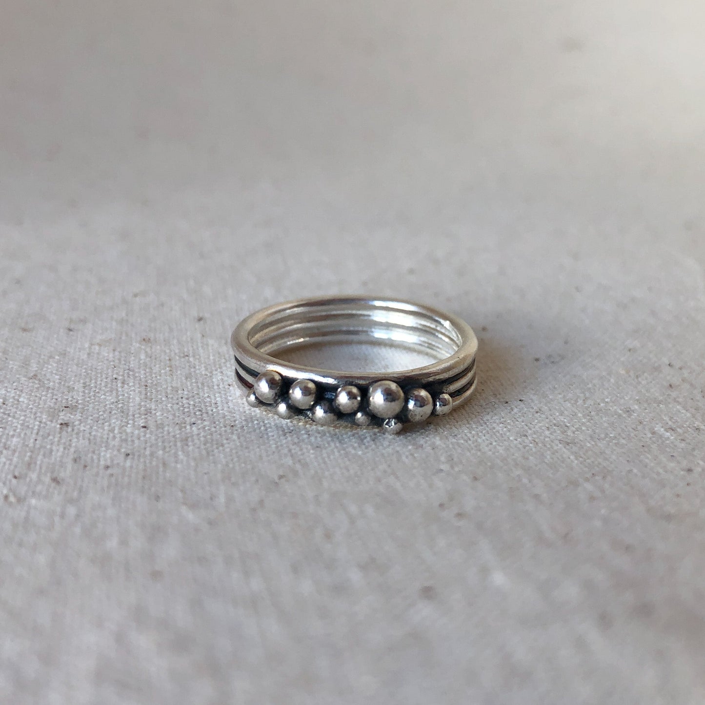Oxidised triple band ring on grey background