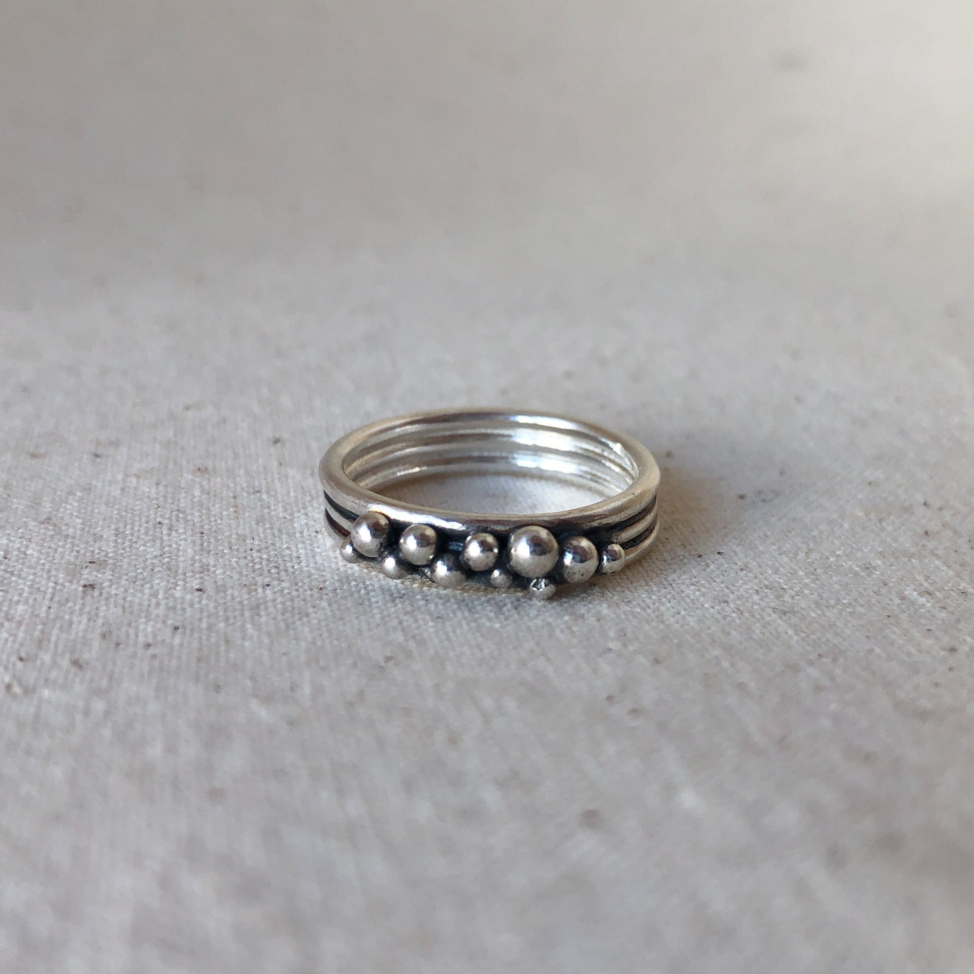 Oxidised triple band ring on grey background