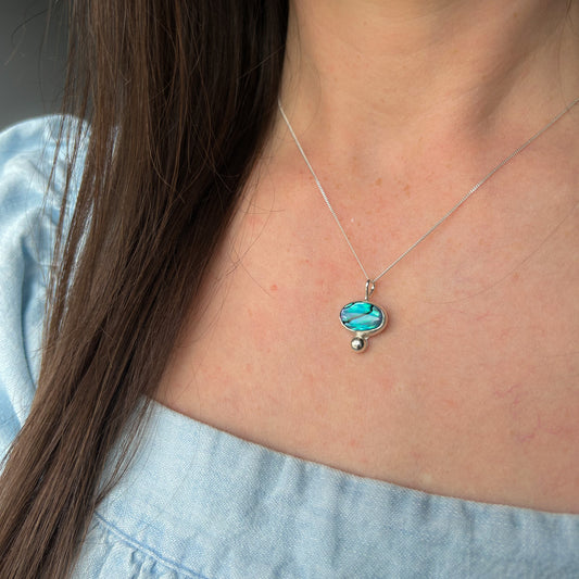 Blue shell necklace shown on models chest 