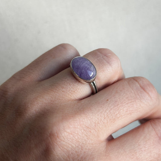 Purple amethyst ring with silver band on model's finger