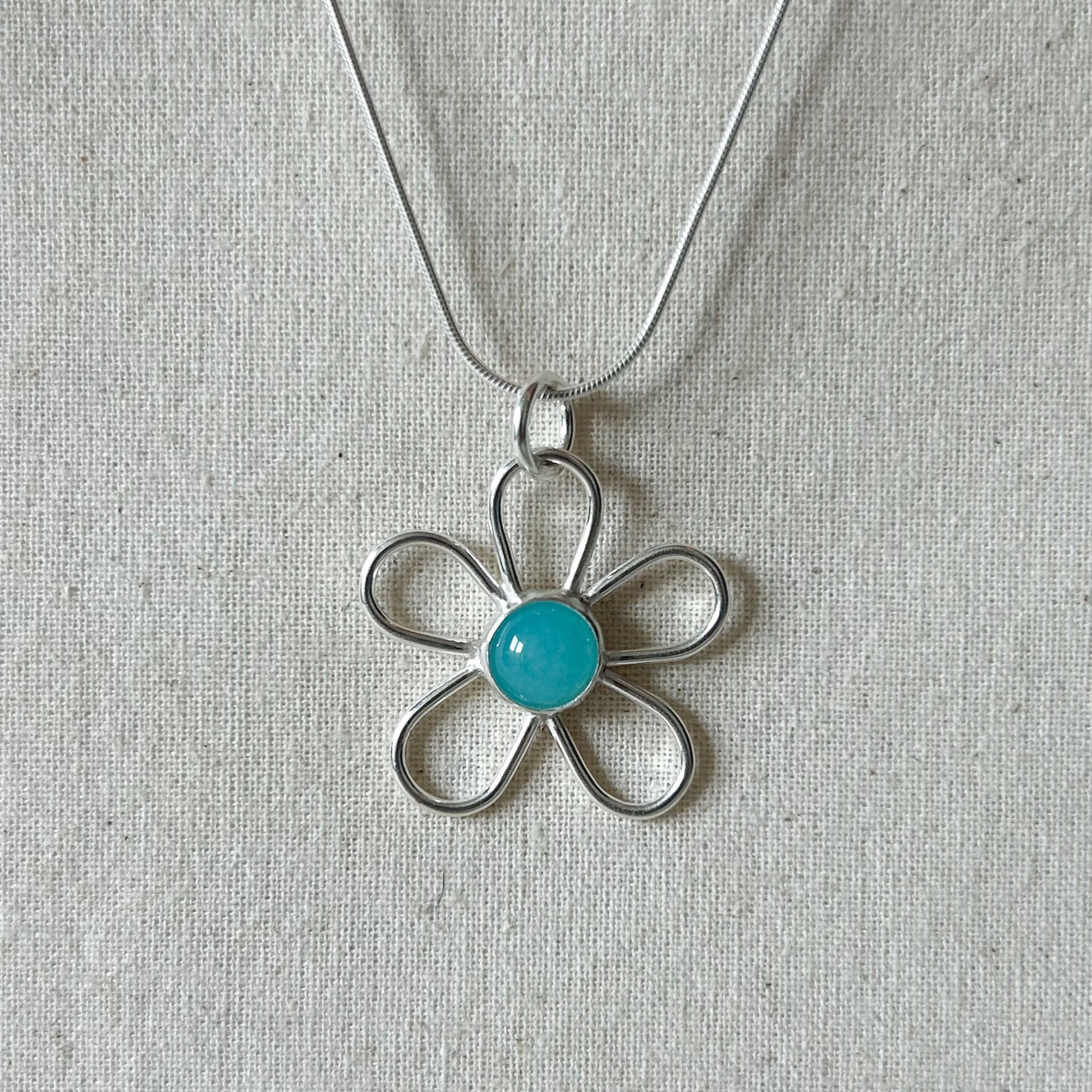 Silver necklace with blue Centre stone.