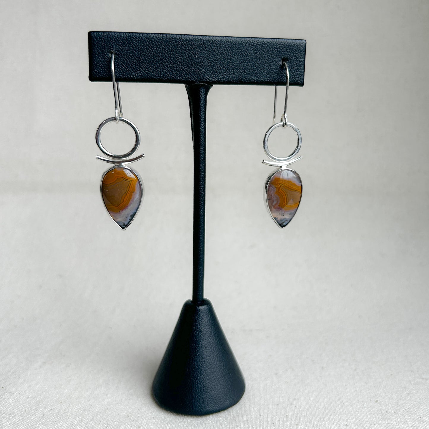 Botswana Agate dangle earrings on black display stand 