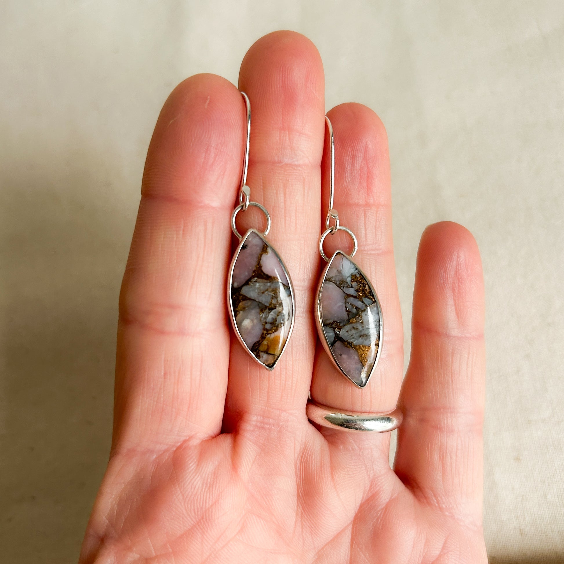 Pink Opal earrings being shown on hand 