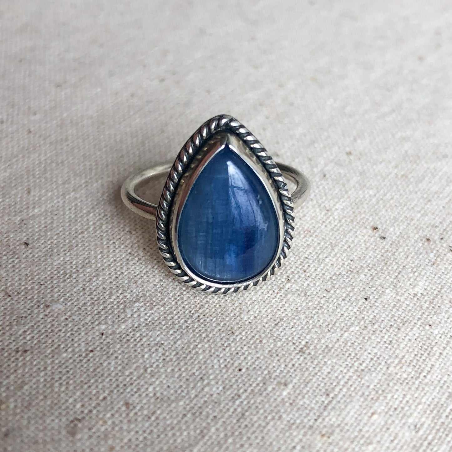 Kyanite ring with a sterling silver band against a grey background