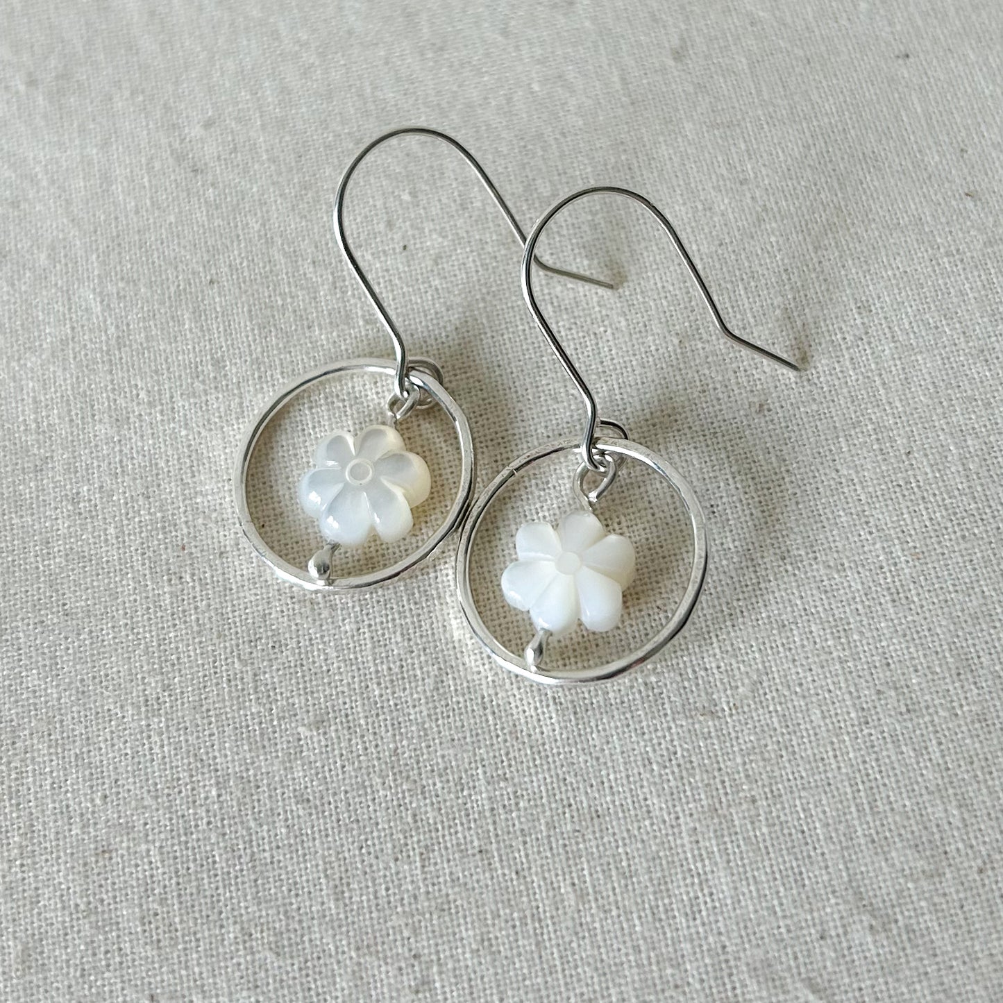 White flower earrings on gray background 